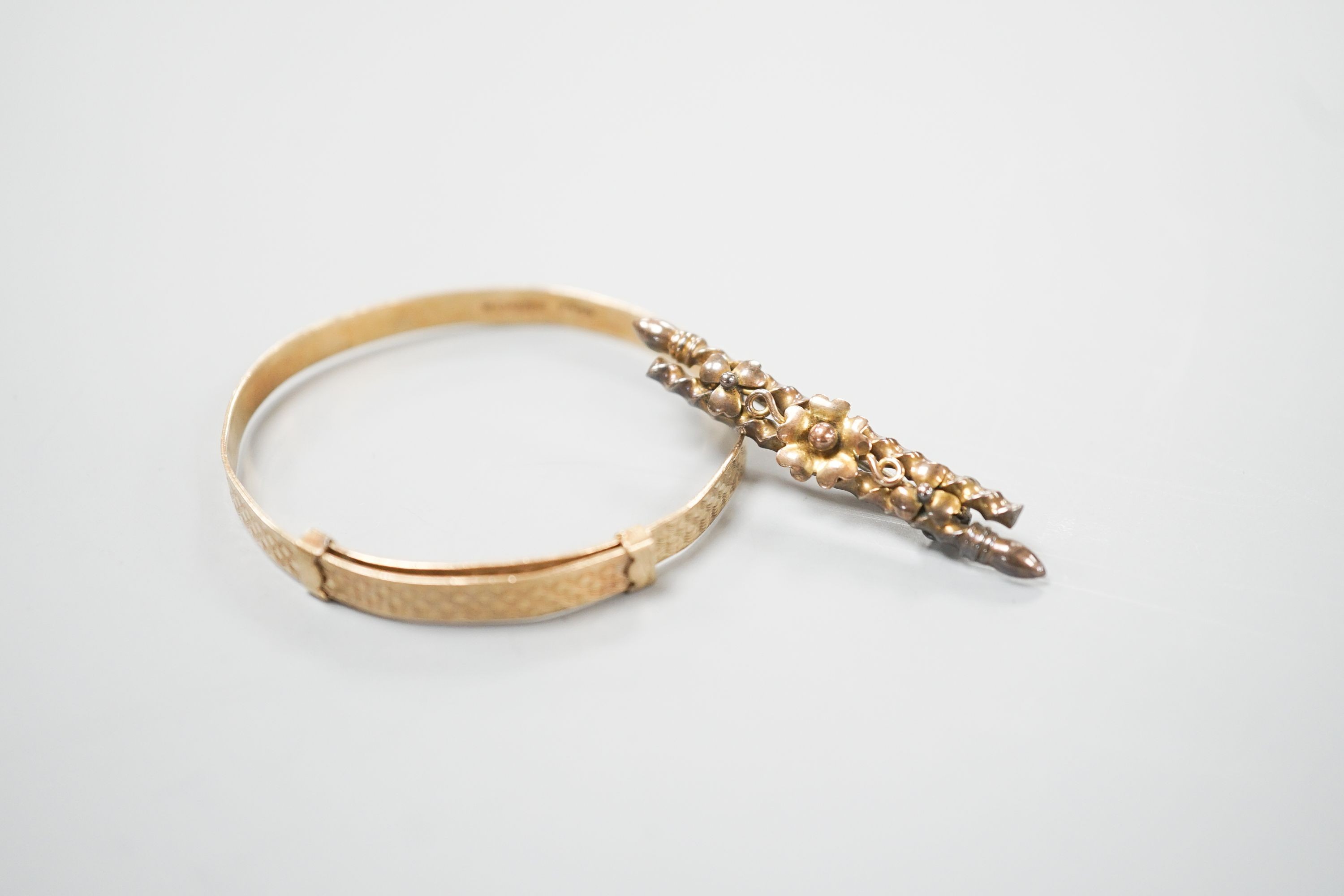 A modern 9ct gold child's bangle and a late Victorian 9ct gold bar brooch, gross 6.7 grams.